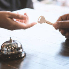 Woman Guest At The Reception Of Hotel Checking In.